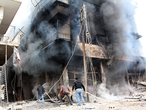 Mannen proberen een brand in een gebouw in Damascus te blussen.