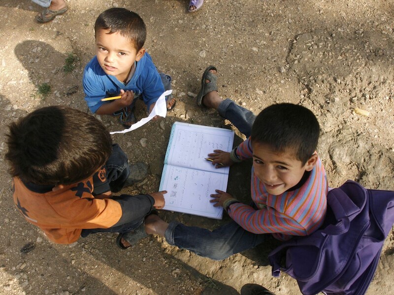 Jonge Syrische vluchtelingen doen hun huiswerk in een VN-vluchtelingenkamp in Libanon.