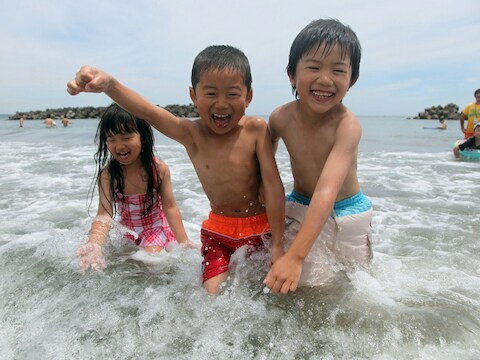Kinderen genieten van afkoeling in de Stille Oceaan