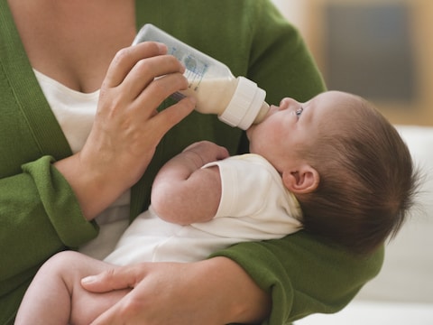 Baby drinkt melk, illustratiebeeld