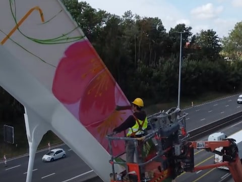 Gaston is volop in de weer om de 16 meter hoge brug tot een fleurig kunstwerk om te toveren.