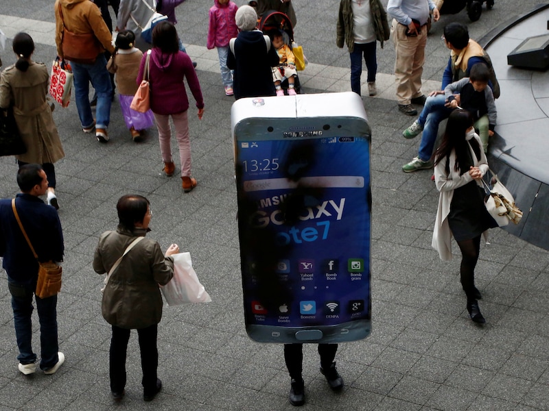 Een grapjas in een 'ontploft' Note 7-kostuum na een Halloweenparade in Tokio.