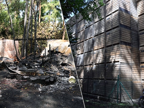 Pal naast de afgebrande chalet is een muur van houten paletten opgetrokken van het landbouwbedrijf. 