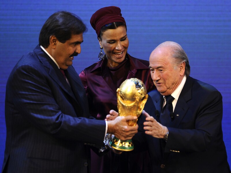 FIFA-baas Sepp Blatter (R) overhandigt de emir van Qatar, sjeik Hamad bin Khalifa Al-Thani, de wereldbeker nadat zij het WK 2022 krijgen toegewezen