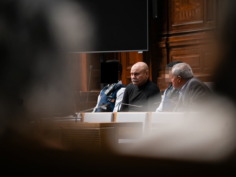 Sukhdev Singh tussen agenten van de bewaking, vergezeld door zijn tolk Punjabi.