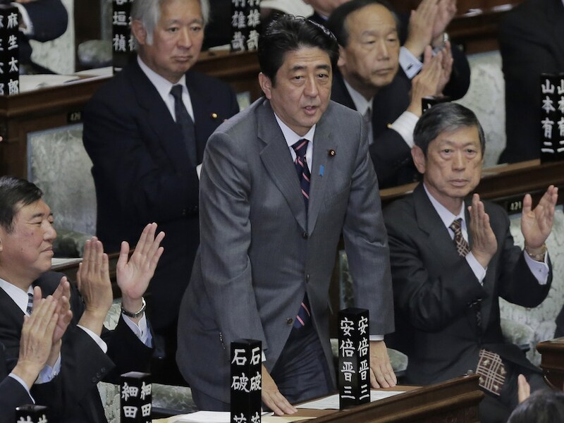 Shinzo Abe (midden) neemt applaus in ontvangst bij zijn herverkiezing.