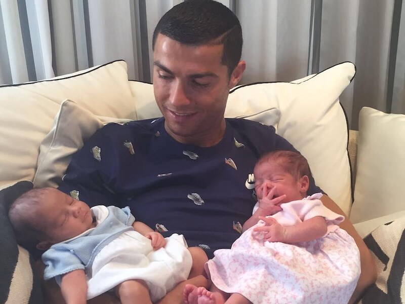 Fiere Cristiano poseert met tweeling op de arm