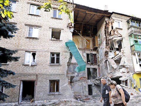 Veel woningen in het oosten van Oekraïne, zoals hier in Snizhne, zijn verwoest. Meer en meer Oekraïners vluchten naar Rusland om aan de gevechten te ontkomen.