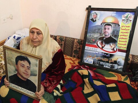 De moeder van de Palestijnse gevangene Ali Abu Fool toont een foto van haar zoon die vanavond vrijgelaten wordt