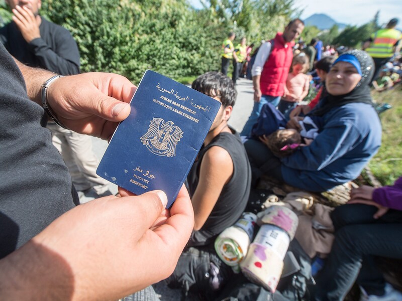 Een Syrische vluchteling toont zijn paspoort.