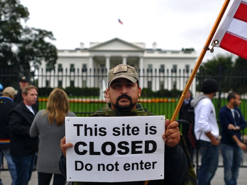 Een betoger toont een bord voor het Witte Huis in Washington.