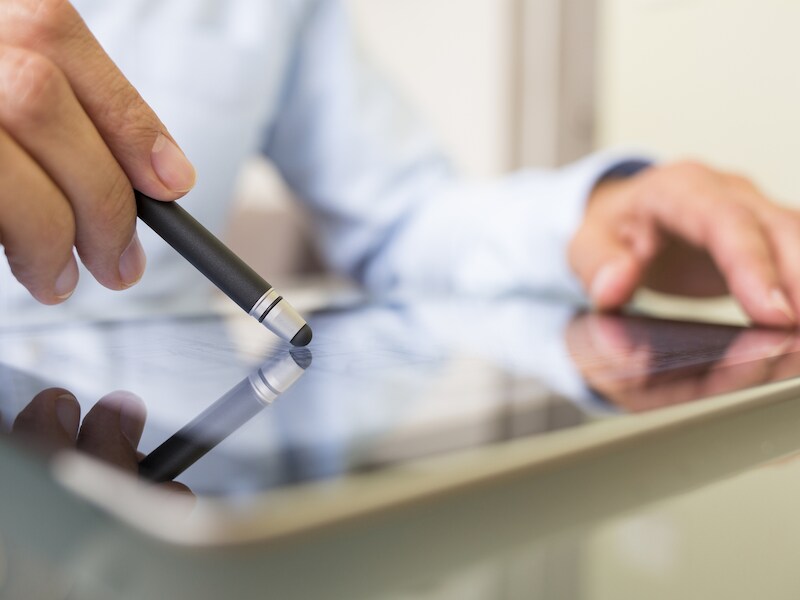 Stockfoto. Met een digitale pen kan er met meer precisie gewerkt worden op een tablet. Handig de zakenwereld?