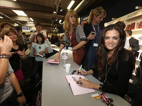 Astrid Bryan signeert haar boek op de boekenbeurs.