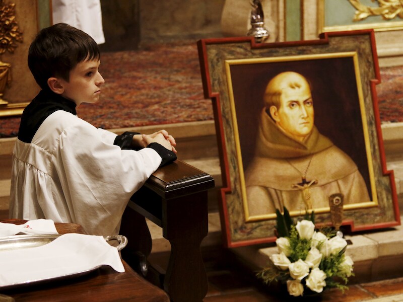 Een misdienaar knielt bij het graf van de Spaanse missionaris Junípero Serra.