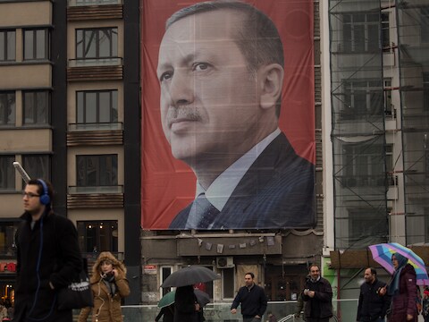 Mensen wandelen op het Taksimplen in Istanbul voorbij een groot portret van Erodgan. Het plein werd in 2013 een tijd ingenomen door tegenstanders van de president. De demonstranten werden hardleers van het plein verdreven.