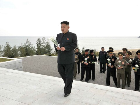 Kim Jong-un legt bloemen bij een gedenkteken voor de slachtoffers.