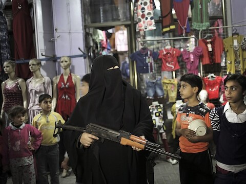 Een vrouw van Hamas houdt een geweer vast tijdens een protestactie na het overlijden van een Palestijnse gevangene in Israël.