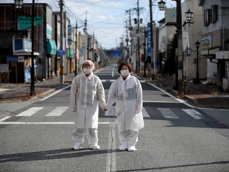 Een koppel in de verlaten straten van Fukushima na de tsunami van 11 maart 2011.