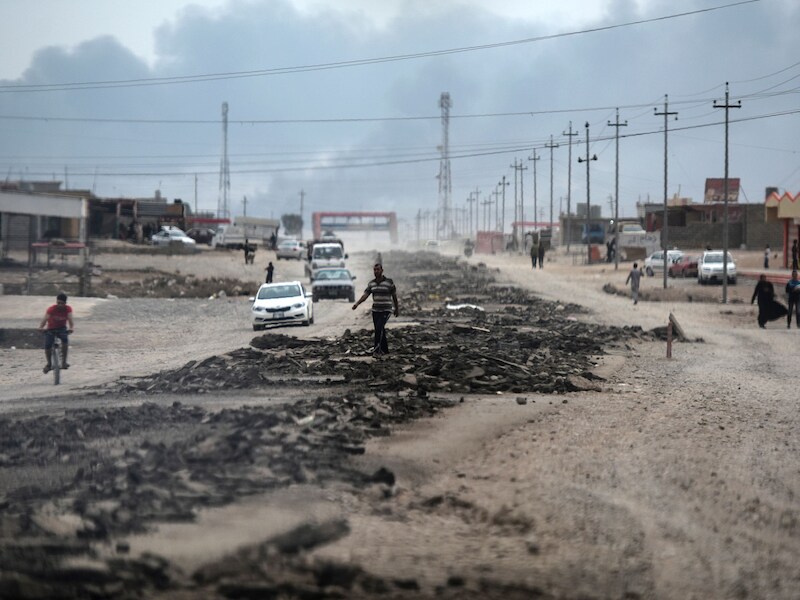 Mensen op een weg tussen Qayyarah en Mosul tijdens de operatie van Irakese krachten om de stad te heroveren op IS.
