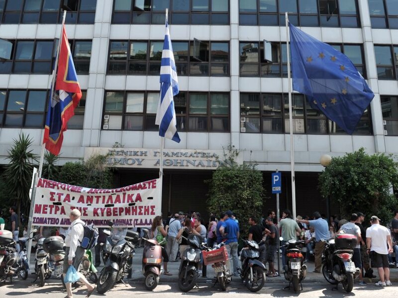 Werknemers overheidsdiensten protesteren voor een bezet overheidsgebouw in Athene.