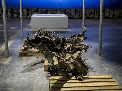 Resten van de bomauto die Breivik in Oslo tot ontploffing bracht, worden tentoongesteld voor een foto van het eiland Utoya, waar hij een dodelijke raid uitvoerde.