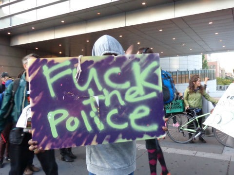Een betoger met 'Fuck the Police' op een bord in Ferguson.
