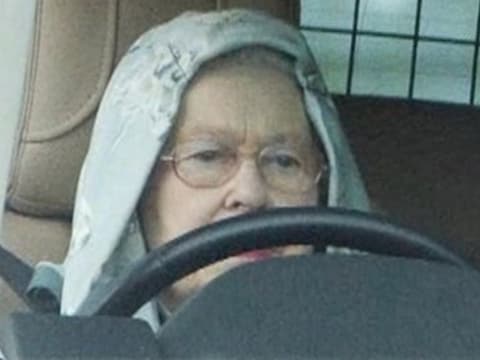 De Britse Queen in slobbertrui en met kap op het hoofd. © videostill YouTube